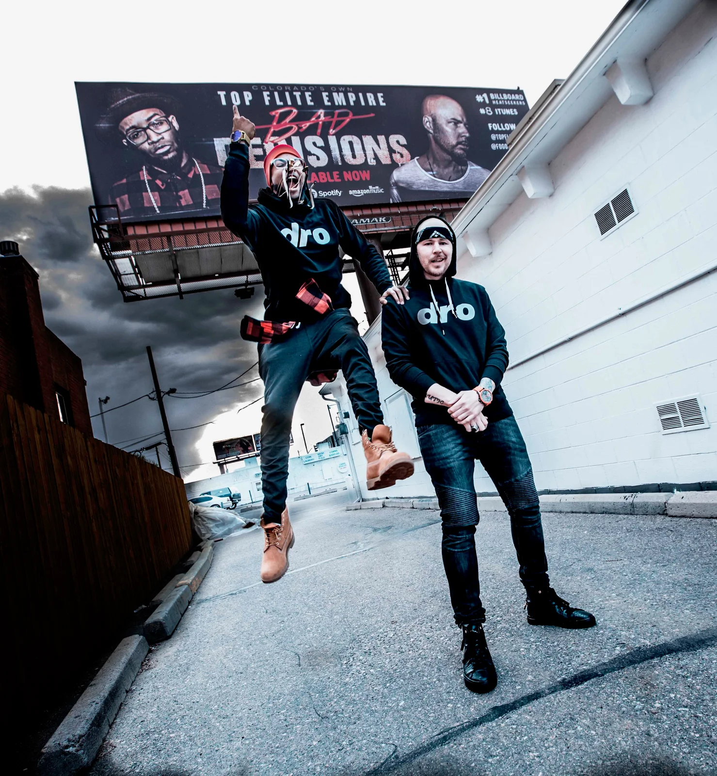 Top Flite Empire poses in front of their Bad Decisions billboard in Denver, featuring Hypnautic and King Tef promoting their album