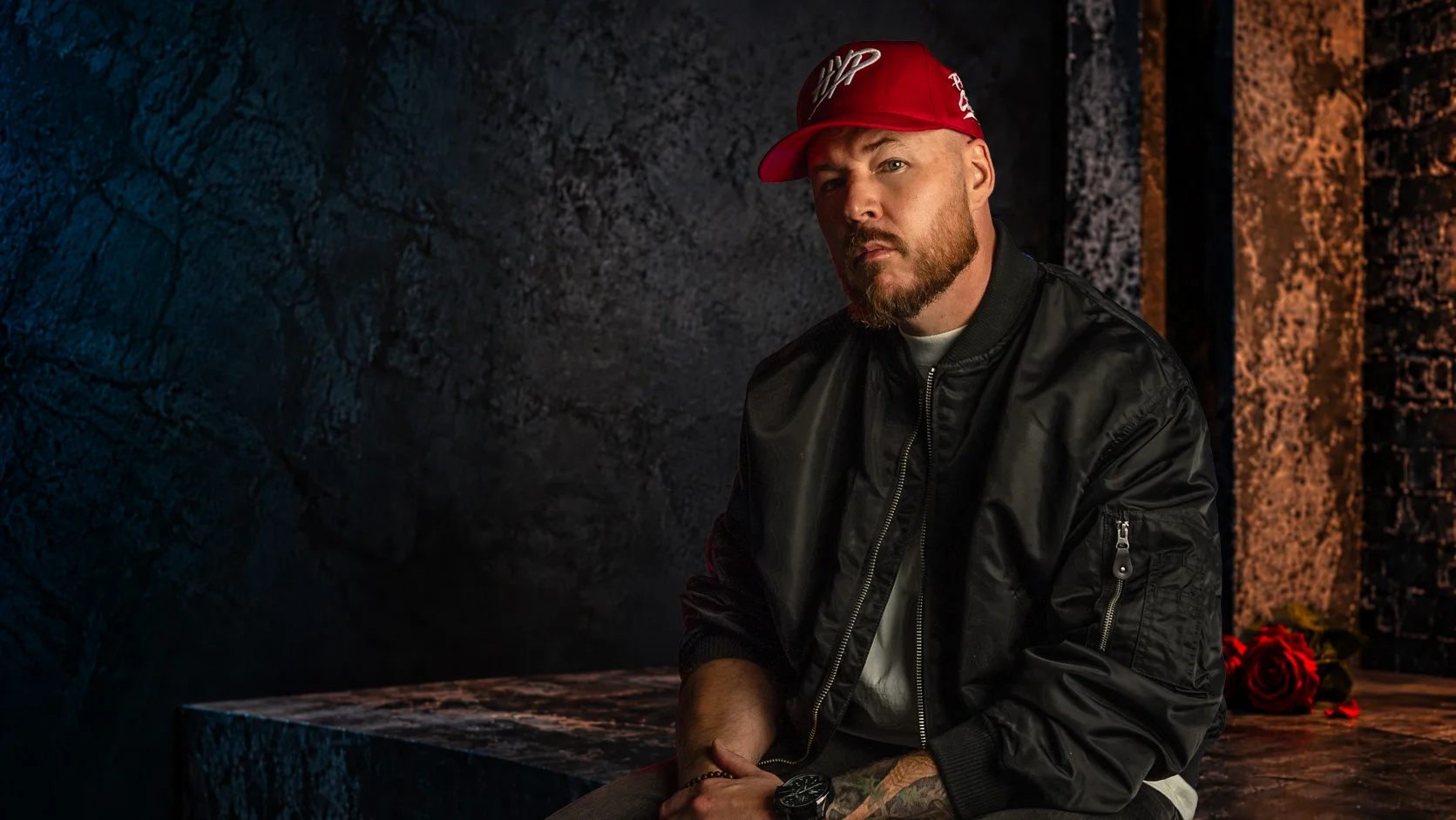 Hypnautic seated in a concrete room wearing his red HYP cap